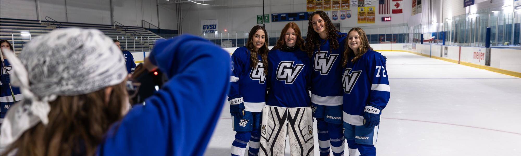 A student photographer taking photos of the women's hockey team